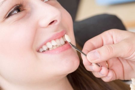 woman-smiling-as-dentist-checks-veneer